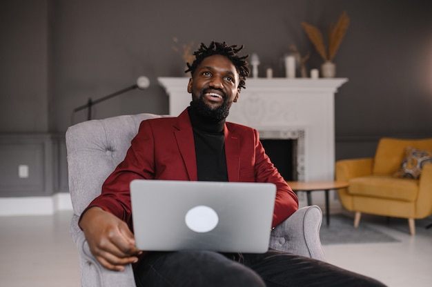 Um homem negro trabalha em um laptop, close-up de suas videoconferências