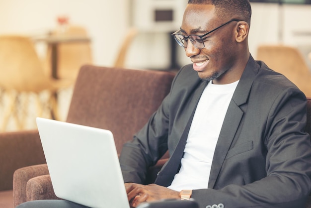 Um homem negro trabalha em um tablet no saguão do hotel