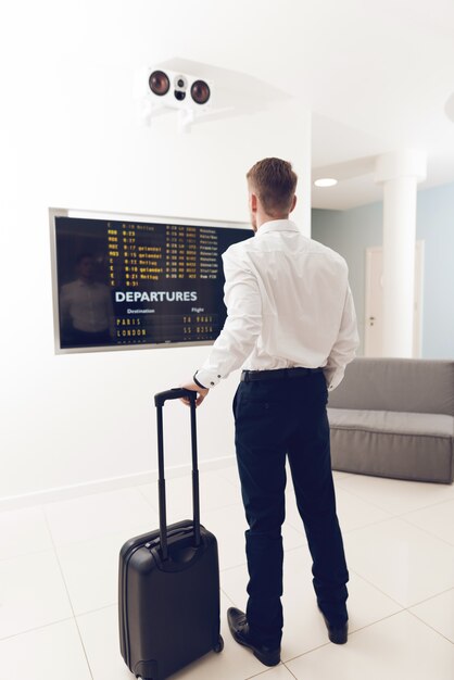 Um homem no aeroporto observa o cronograma.