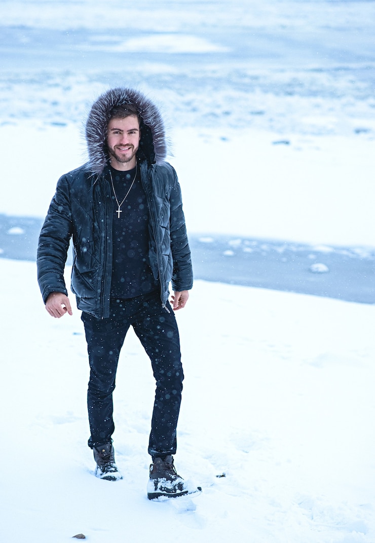 Foto um homem no inverno em um fundo de neve com roupas pretas