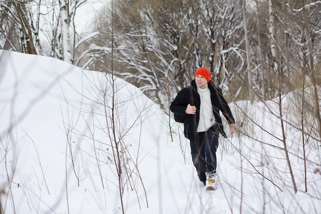 Um homem no inverno na floresta. um turista com uma mochila atravessa a floresta no inverno. ascensão de inverno.