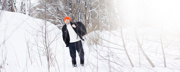 Um homem no inverno na floresta. Um turista com uma mochila atravessa a floresta no inverno. Subida de inverno.