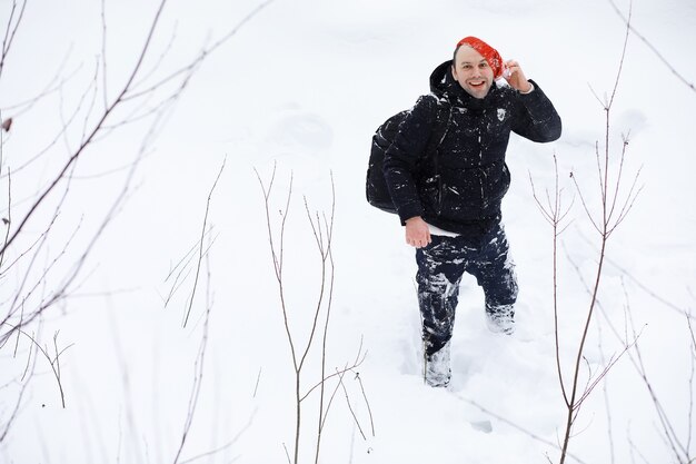 Um homem no inverno na floresta. Um turista com uma mochila atravessa a floresta no inverno. Subida de inverno.