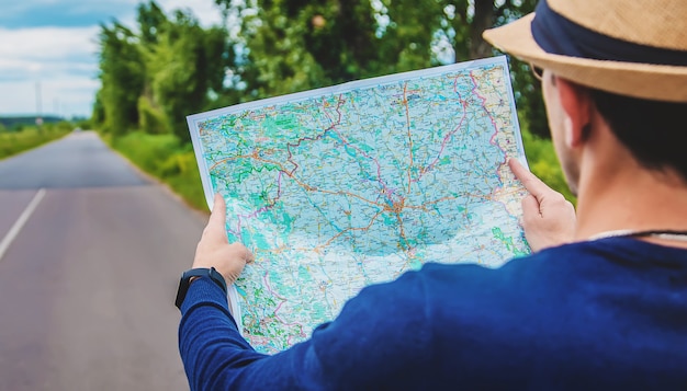 Um homem olha um mapa na estrada