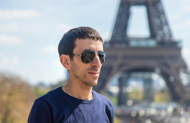 Um homem perto da torre eiffel foco seletivo