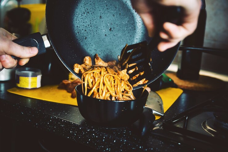 Foto um homem prepara comida tradicional chinesa em casa no wok
