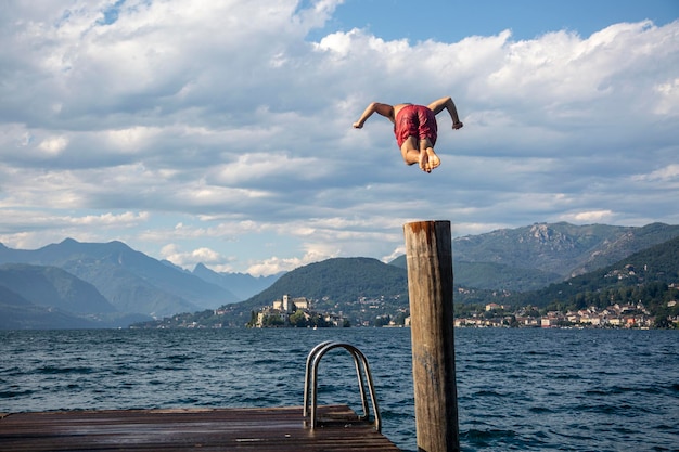 Um homem pula na água do lago Orta, na Itália