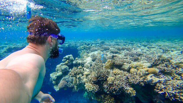 Um homem que praticava mergulho com snorkel mergulhou no fundo do Mar Vermelho e tirou fotos de si mesmo contra o fundo de corais