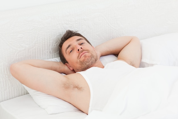 Um homem relaxado em sua cama antes de acordar