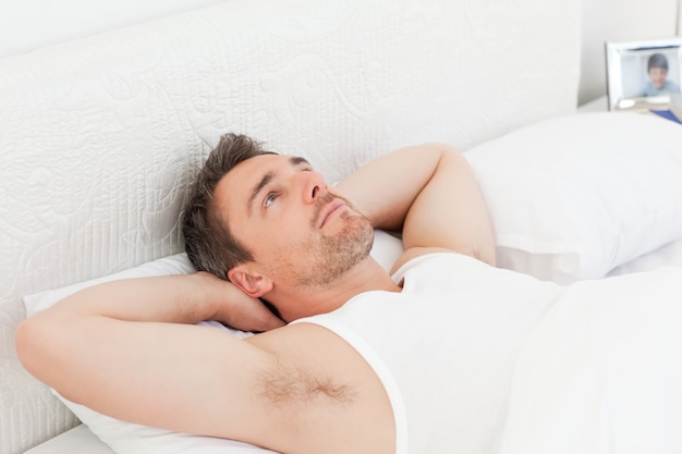 Um homem relaxado em sua cama antes de acordar