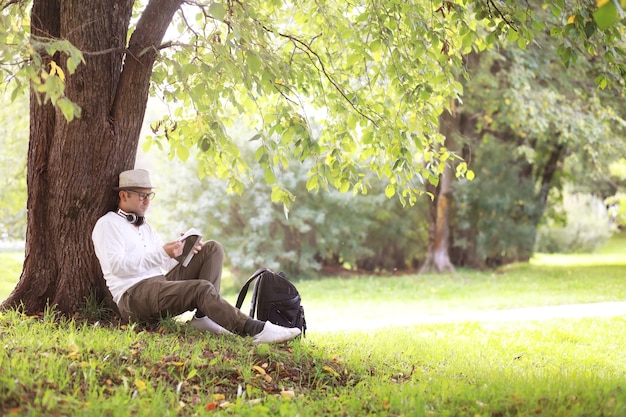 Um homem se esconde à sombra das árvores em um dia quente. Pausa para o almoço. Descanse no meio da jornada de trabalho.