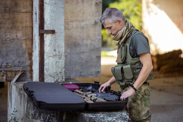 Um homem se preparando para o jogo de airsoft em uniforme militar