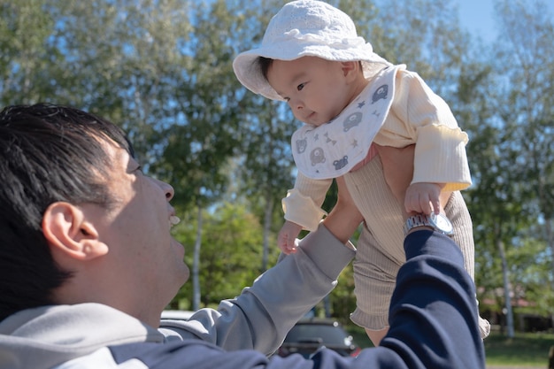 Um homem segurando um bebê no ar