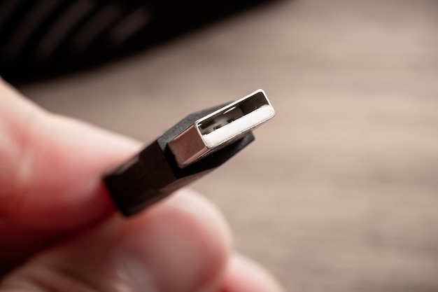 um homem segurando um cabo USB em macro fotografia