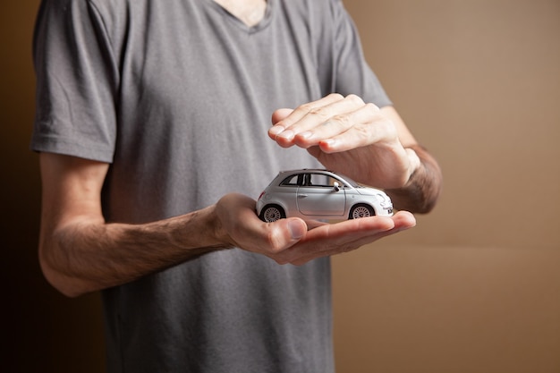 Um homem segurando um carrinho de brinquedo nas mãos