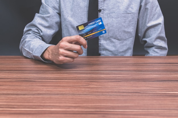 Um homem segurando um cartão de crédito