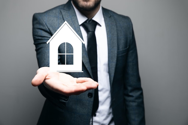 Um homem segurando um ícone de casa na mão