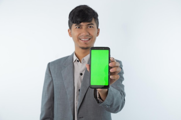 Um homem segurando um smartphone com tela verde