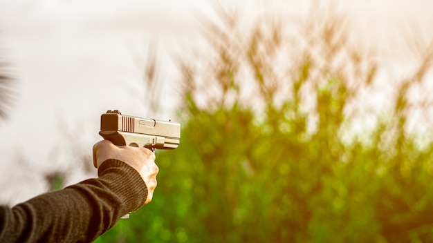 Um homem segurando uma arma na mão. - conceito de violência e crime.