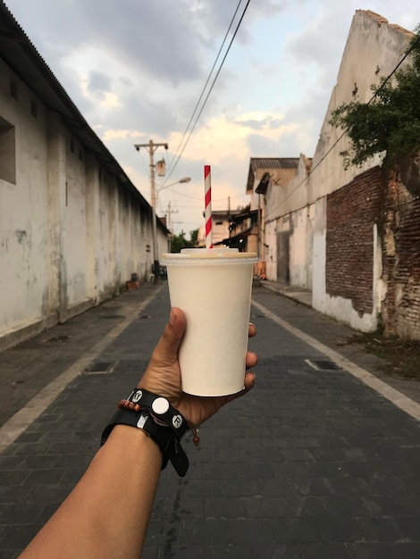 um homem segurando uma chávena de café com a mão