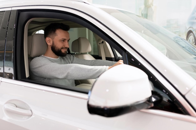 Um homem senta-se ao volante de um carro e se prepara para comprá-lo