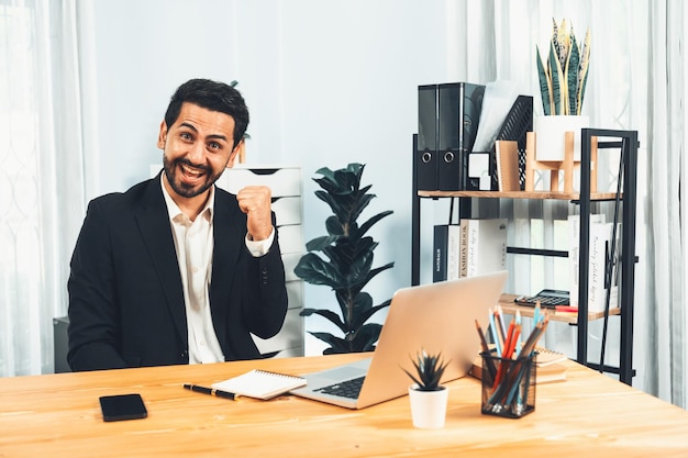 Um homem sentado em uma mesa com um laptop e um laptop.