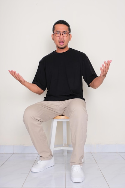 Um homem sentado na cadeira mostrando uma expressão confusa