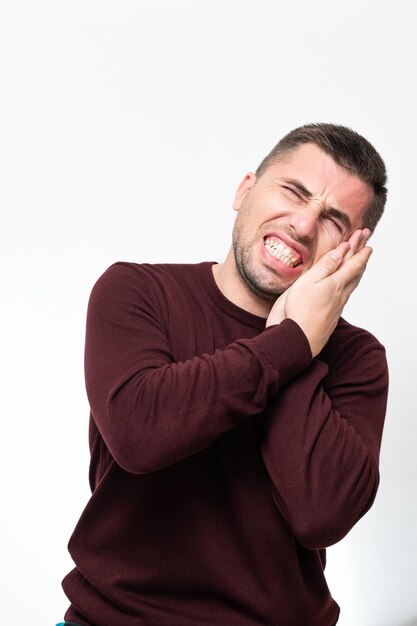 Um homem sofre de um retrato de dor de dente em um fundo branco