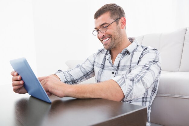 Um homem sorridente usando um tablet