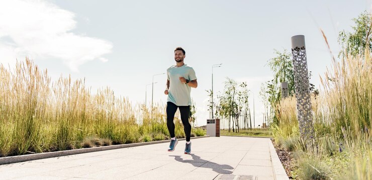 Foto um homem sorrindo corredor de aquecimento em uma camiseta para esportes ativos vista traseira de um dia ensolarado treinador um treina