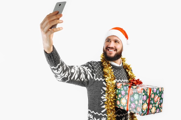 Um homem tira uma foto com um estúdio de presente de Natal em fundo branco