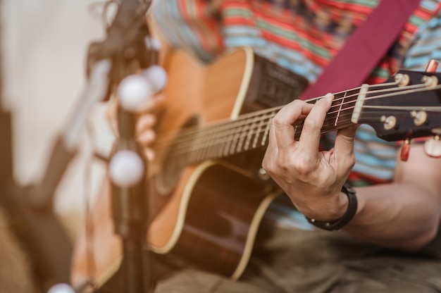 Um homem tocando violão no palco de um festival de música. Concerto, mini concerto e festivais de música.