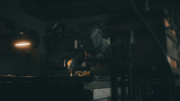 Um homem trabalha com uma máquina de soldagem em uma fábrica