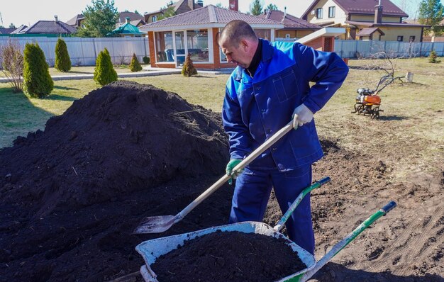 Um homem trabalha em uma horta no início da primavera