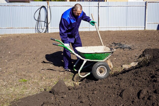 Um homem trabalha em uma horta no início da primavera