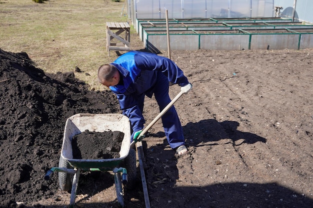 Um homem trabalha em uma horta no início da primavera