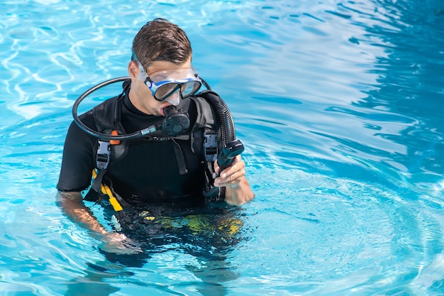 Um homem treinando equipamento de mergulho na piscina