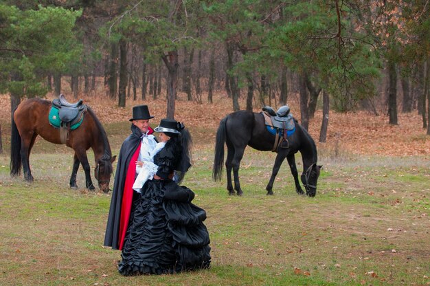 Um homem uma mulher em roupas velhas e cavalos