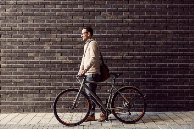 Um homem urbano empurrando bicicleta na rua