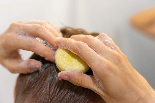 Foto um homem usa uma barra de xampu sólido no banheiro uma aplicação de xampu no couro cabeludo cuidados capilares sustentáveis livre de plástico, zero desperdício, ingredientes vivos com baixo teor de água responsabilidade pela natureza