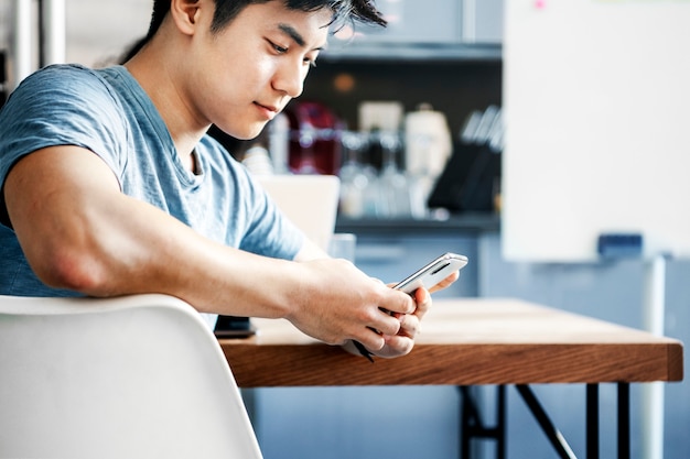 Um homem usando um smartphone em um café