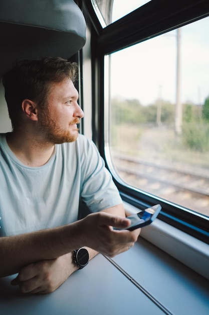 Um homem usando um smartphone enquanto viaja de trem