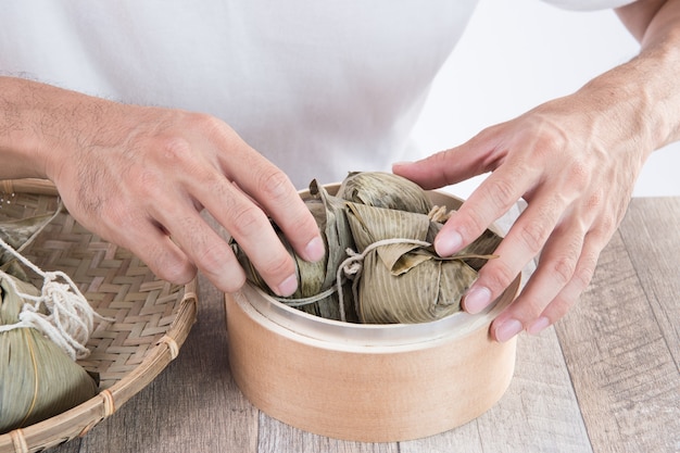 Um homem vai comer zongzi ou bolinho de arroz no Dragon Boat Festival, comida tradicional asiática