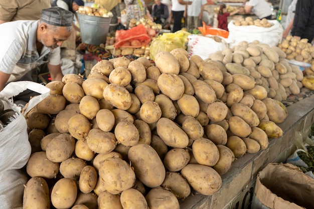 Um homem vendendo batatas em um mercado