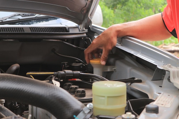 Foto um homem verificando o motor do carro em um trabalhador em casa