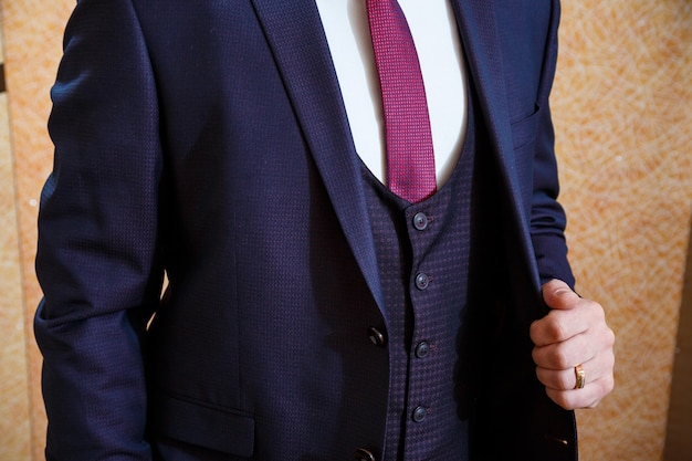 Um homem veste um terno masculino no dia do casamento