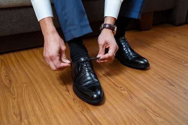 Um homem veste um terno masculino no dia do casamento