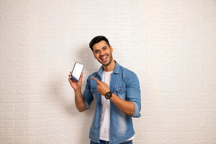 Foto um homem vestindo uma jaqueta de jeans azul está segurando um telefone que diz polegar para cima