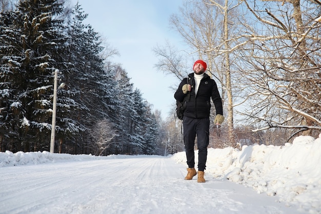 Um homem viaja com uma mochila. Caminhada de inverno na floresta. Turista em uma caminhada no inverno no parque.