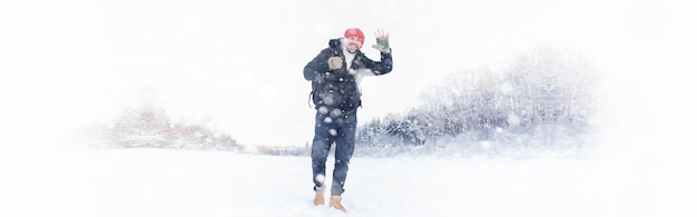 Um homem viaja com uma mochila. Caminhada de inverno na floresta. Turista em uma caminhada no inverno no parque.